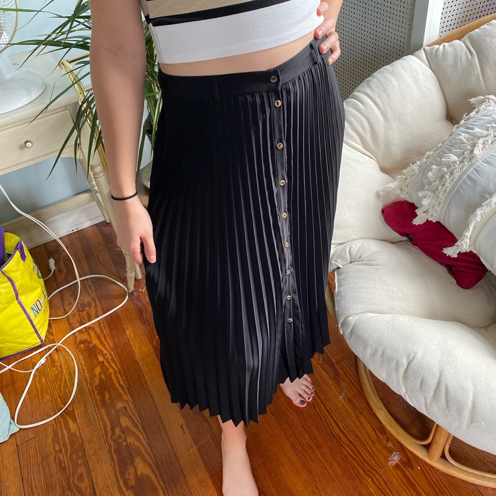 Black high-waisted pleated skirt.